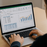 Curso de Programación de Algoritmos con Excel: Persona trabajando en una hoja de cálculo con fórmulas y gráficos en la pantalla de un ordenador portátil.